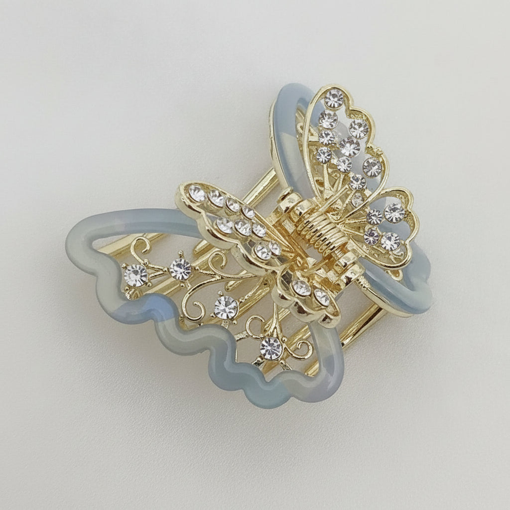 Gold-Tone Blue Butterfly Hair Claw Clip. Featuring translucent resin wings and sparkling crystals curated by Ladylike Accoutre.