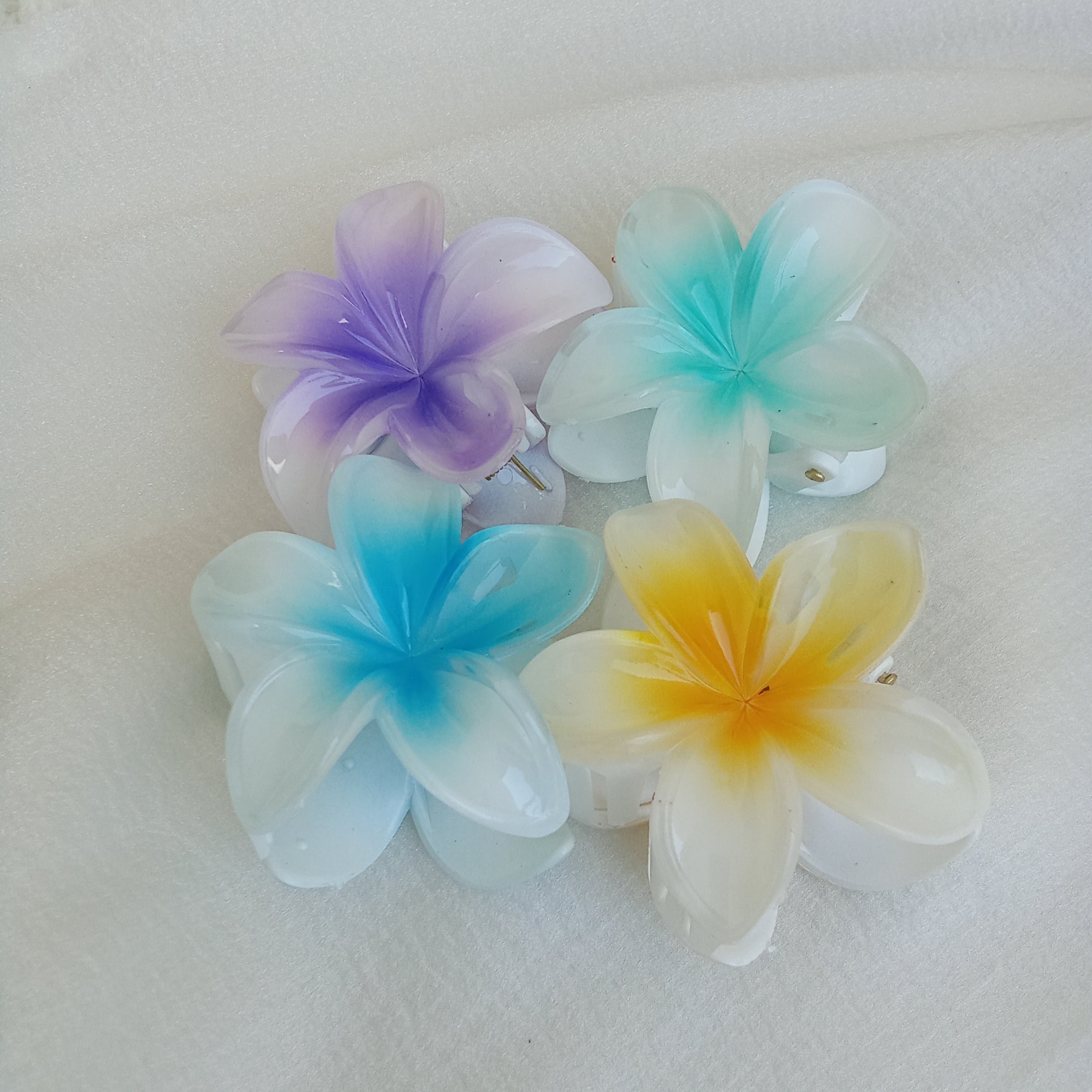 Plumeria Flower Hair Claw Clip, Set of 4 Clips. Featuring tropical gradient designs in Purple, Blue, Green & Yellow.