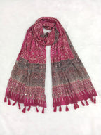 Magenta Pakistani print georgette dupatta with mirror work embellishments and tassels spread out on a white surface. Curated by Ladylike Accoutre.