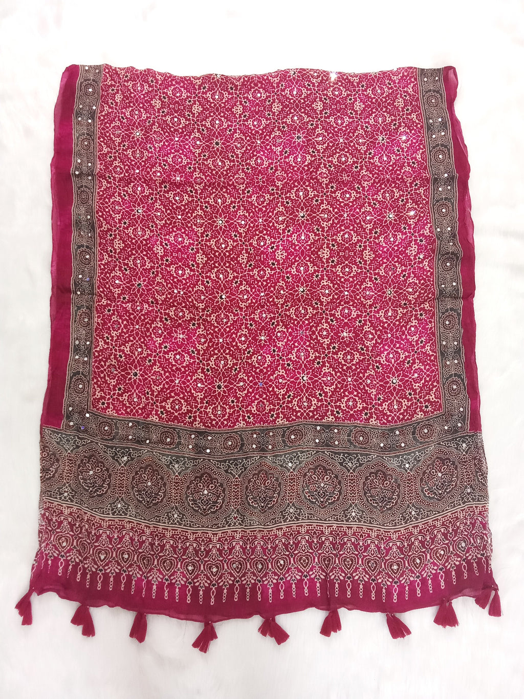 Magenta Pakistani print georgette dupatta with mirror work embellishments and tassels spread out on a white surface. Curated by Ladylike Accoutre.