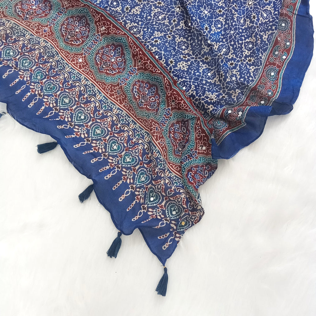 Blue Pakistani print georgette dupatta with mirror work embellishments and tassels spread out on a white surface. Curated by Ladylike Accoutre.