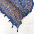 Blue Pakistani print georgette dupatta with mirror work embellishments and tassels spread out on a white surface. Curated by Ladylike Accoutre.