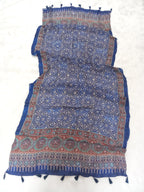 Blue Pakistani print georgette dupatta with mirror work embellishments and tassels spread out on a white surface. Curated by Ladylike Accoutre.