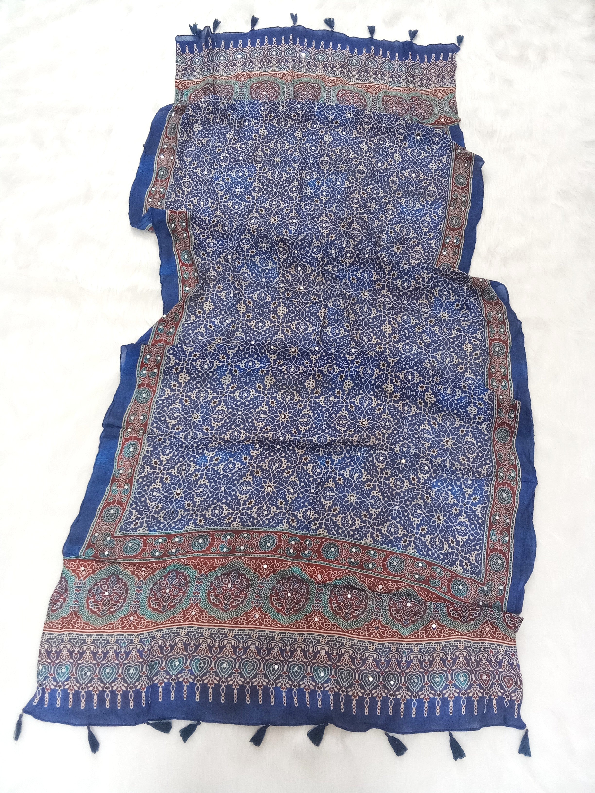Blue Pakistani print georgette dupatta with mirror work embellishments and tassels spread out on a white surface. Curated by Ladylike Accoutre.