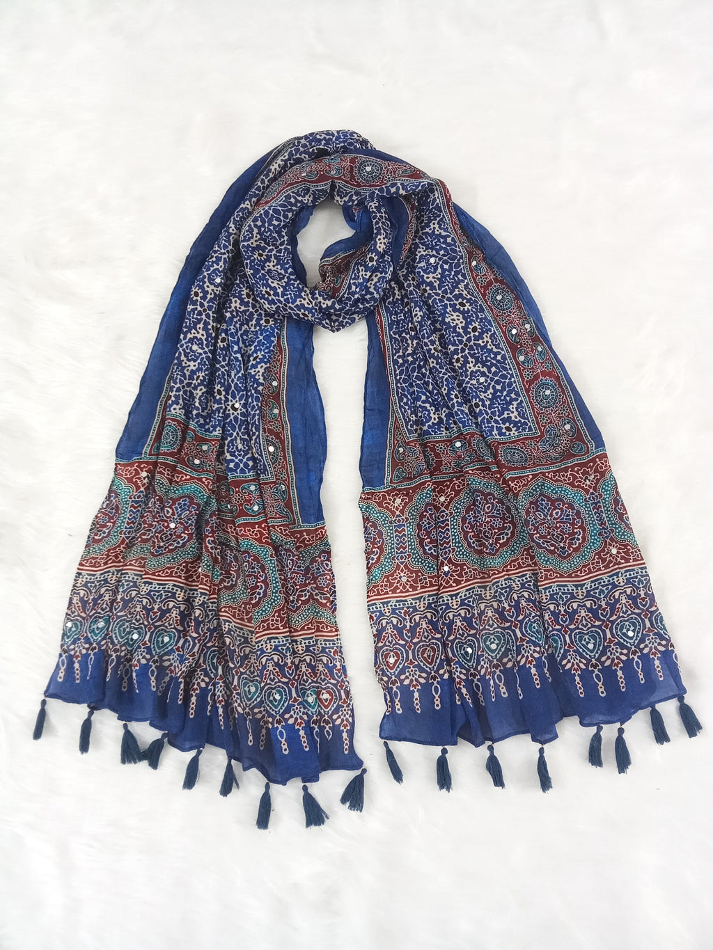 Blue Pakistani print georgette dupatta with mirror work embellishments and tassels spread out on a white surface. Curated by Ladylike Accoutre.