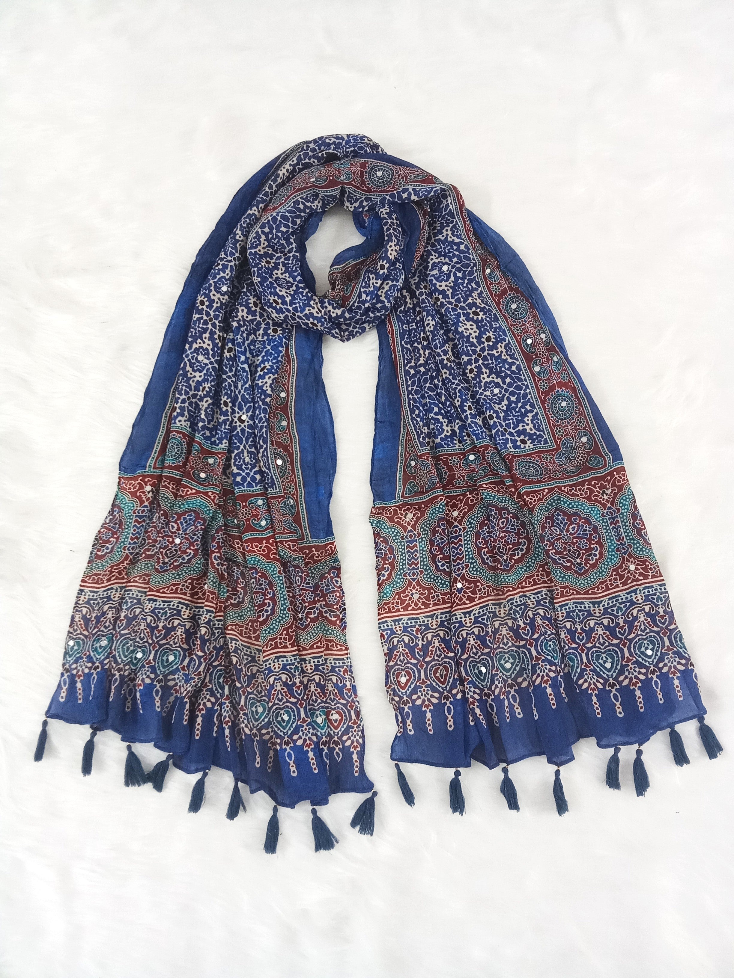 Blue Pakistani print georgette dupatta with mirror work embellishments and tassels spread out on a white surface. Curated by Ladylike Accoutre.