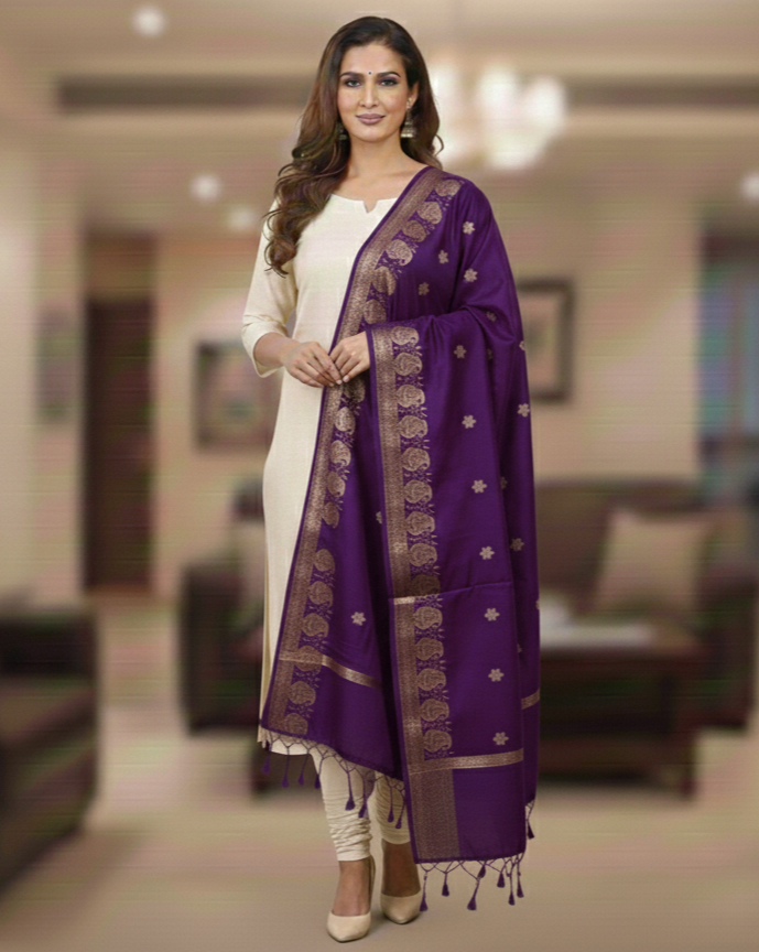 A model in cream salwar kameez wearing a Banarasi-inspired Purple Art Silk Dupatta with Tassels by Ladylike Accoutre, displayed on a clean white background. Features gold zari butti floral motifs and an intricate paisley border.