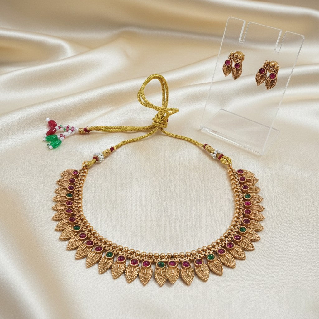 Gold-Tone Traditional Leaf Motif Necklace Set with Ruby-Red & Emerald-Green Accents and adjustable dori set on a cream shining background by Ladylike Accoutre
