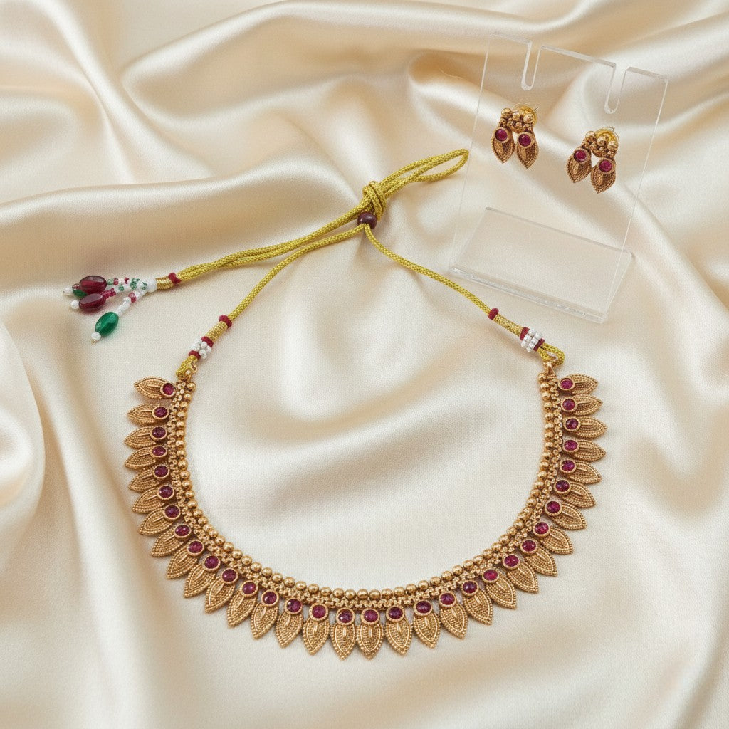 Gold-Tone Traditional Leaf Motif Necklace Set with Ruby-Red Accents and adjustable dori set on a cream shining background by Ladylike Accoutre