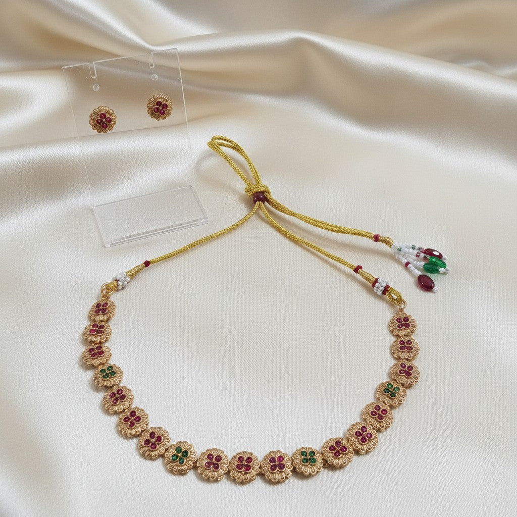 Gold-Tone Floral Temple Choker Necklace Set with Ruby-Red & Emerald-Green Stones & Matching Stud Earrings and adjustable dori set on a cream shining background by Ladylike Accoutre