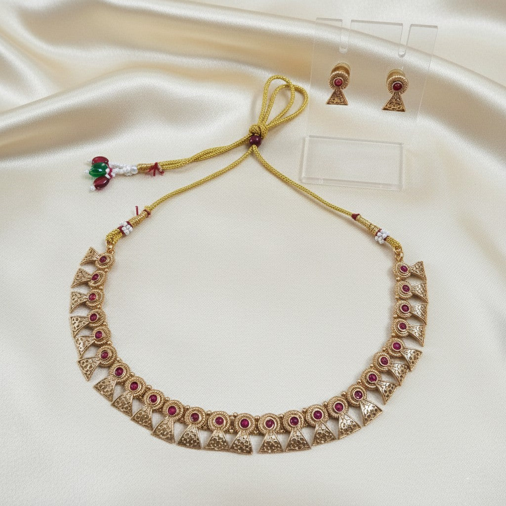 Gold-Tone Traditional Ruby-Red Stone Choker Necklace Set with Matching Earrings and adjustable dori set on a cream shining background by Ladylike Accoutre
