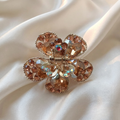 Gold-Tone Crystal Flower Hair Claw Clip in peach, adorned with sparkling heart-shaped crystals.