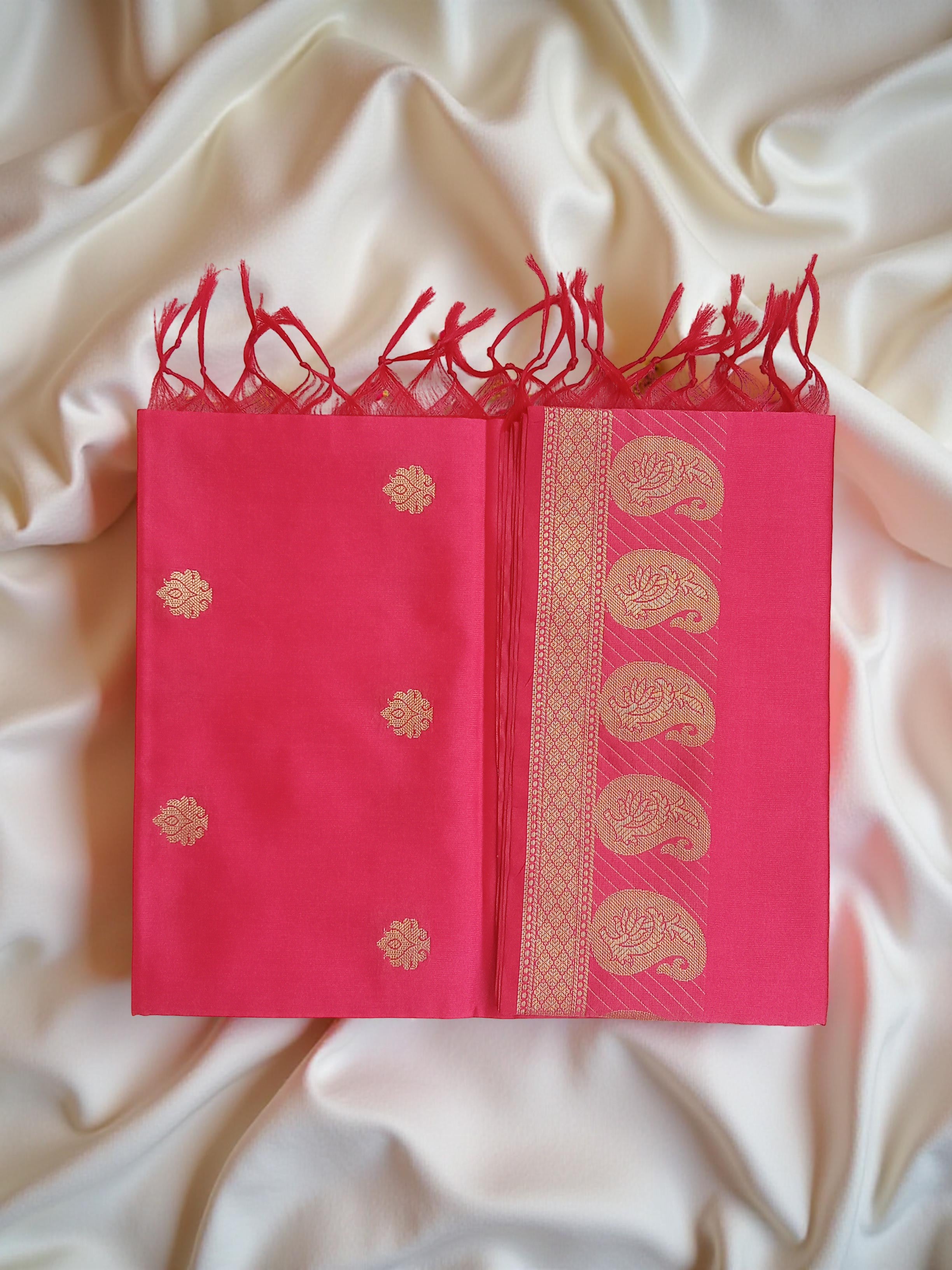 A Banarasi-inspired Reddish Pink Art Silk Dupatta with Tassels by Ladylike Accoutre, displayed on a clean white silky background. Features gold zari butti floral motifs and an intricate paisley border.