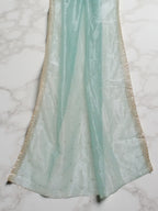 Sea-Green net dupatta with sequin embellishments and gold thread embroidered border set against white marble background by Ladylike Accoutre. 